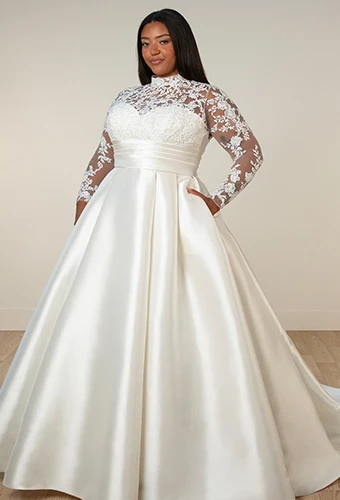 Plus size bride wearing ballgown wedding dress with long lace sleeves and high neckline