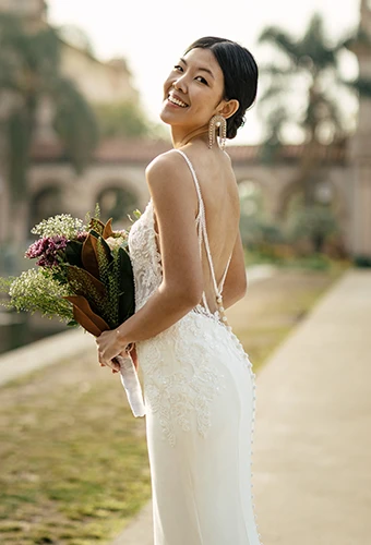 Bride wearing backless fit-and-flare wedding dress with lace details