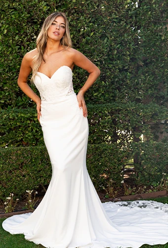 Bride wearing strapless wedding dress with lace train and sweetheart neckline