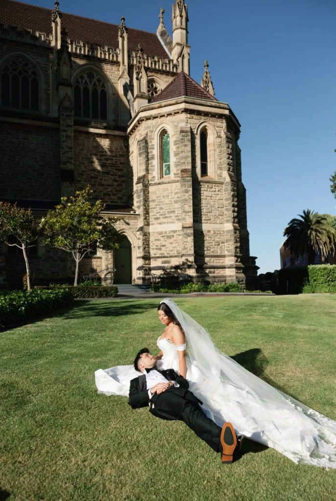 True bride Chloe posing with her husband in front of a cathedral