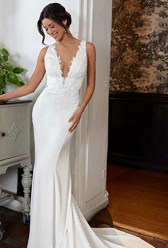 Bride wearing fit and flare wedding dress with deep v-neckline and lace details