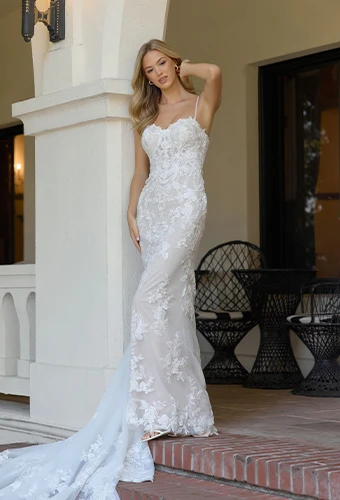 Bride wearing lace fit-and-flare wedding dress with sweetheart neckline and spaghetti straps 