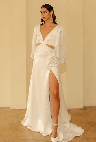 Bride wearing a-line wedding dress with long sleeves and high leg slit