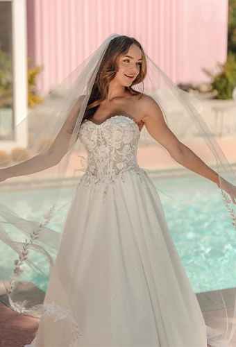 Petite bride wearing strapless lace wedding dress with sweetheart neckline and a-line skirt