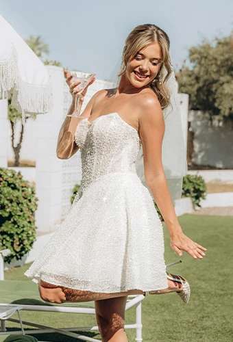Bride wearing sparkling strapless mini wedding dress with sweetheart neckline