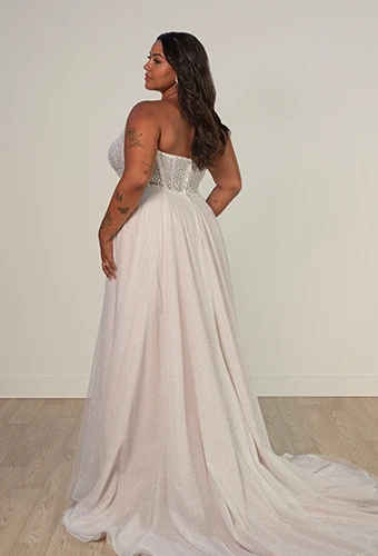 Plus size bride wearing strapless wedding dress with sparkling bodice and detachable overskirt