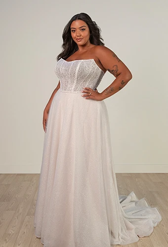 Plus size bride wearing strapless wedding dress with sparkling bodice and detachable overskirt