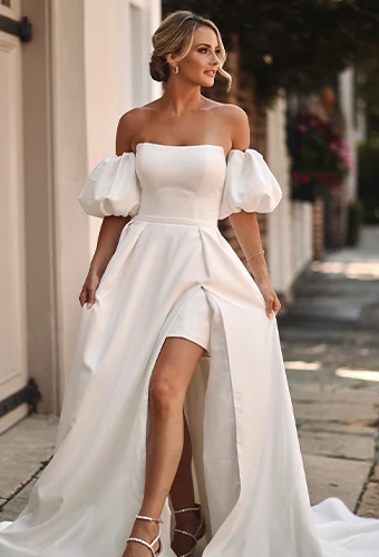 Bride wearing minimalist wedding dress with puff sleeves and overskirt
