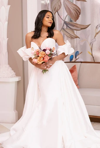 Bride wearing wedding dress with deep sweetheart neckline and overskirt
