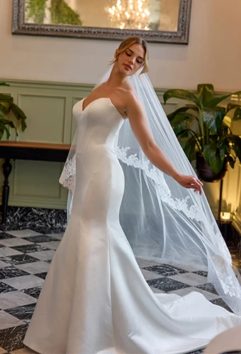 Bride wearing strapless fit-and-flare wedding dress with deep sweetheart neckline