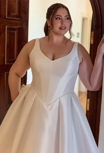 Plus size bride wearing ballgown wedding dress with straps and v-neckline