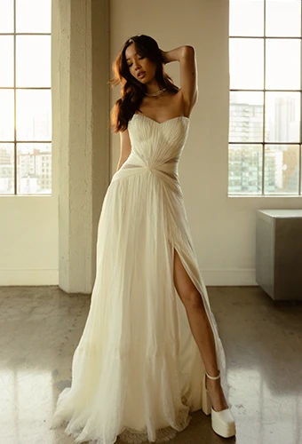 Bride wearing strapless chiffon wedding dress with high leg slit