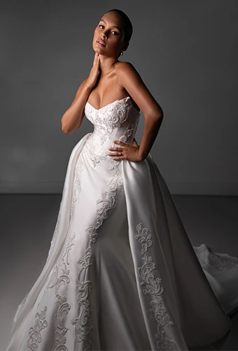 Bride wearing strapless wedding dress with overskirt and lace details