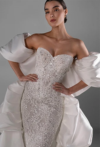 Bride wearing sparkling lace wedding dress with overksirt