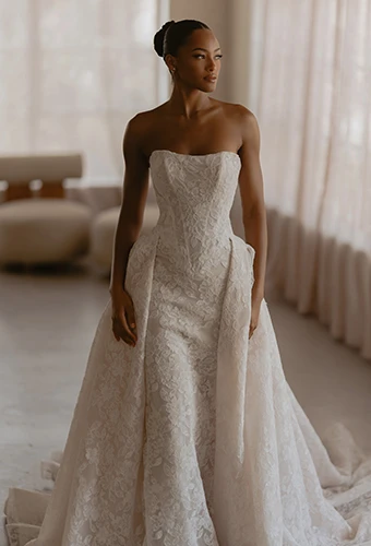 Bride wearing lace wedding dress with sweetheart neckline and overskirt