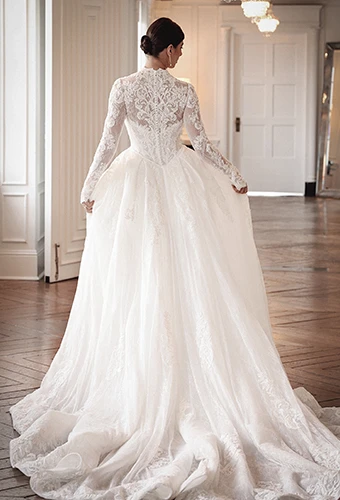 Bride wearing lace wedding dress with detachable overskirt and long sleeves