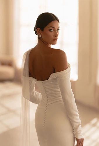 Bride wearing simple wedding dress with long off the shoulder sleeves