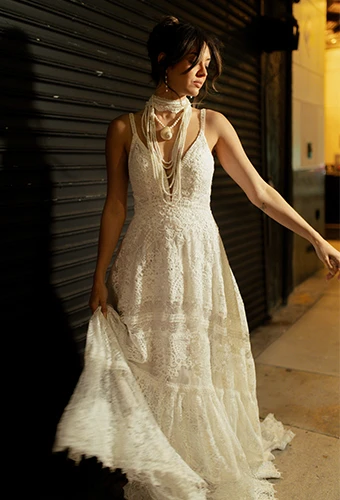 Bride wearing boho lace wedding dress with plunging v-neckline