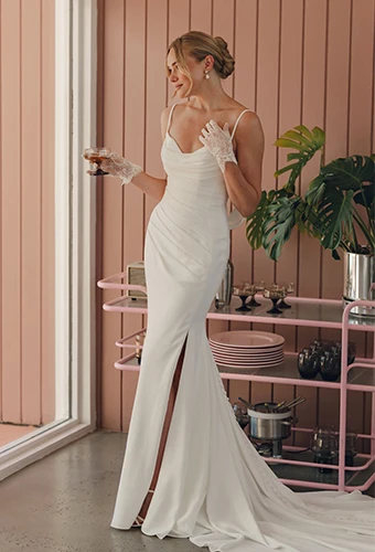 Bride wearing crepe sheath wedding dress with sweetheart neckline and high leg slit