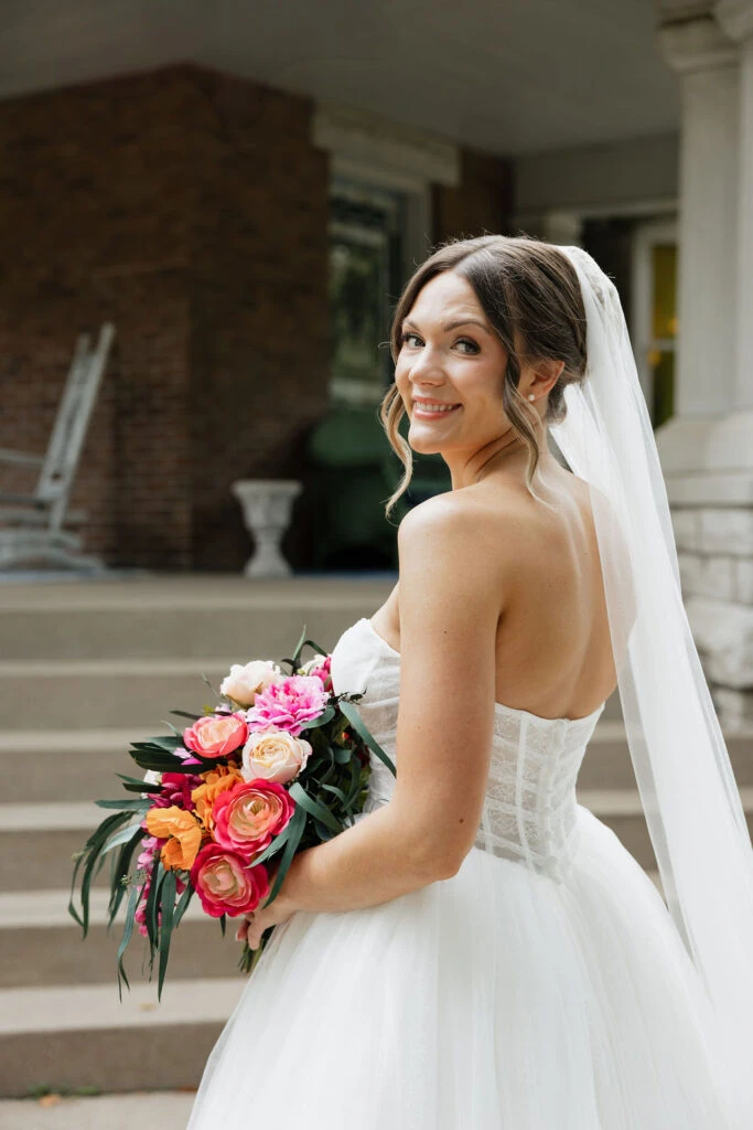 True bride Lauren posing in her wedding gown with her bridal bouquet