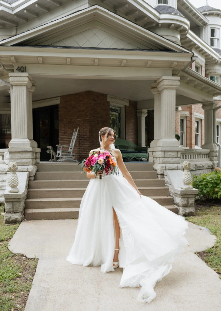 True bride Lauren posing in her wedding gown with her bridal bouquet