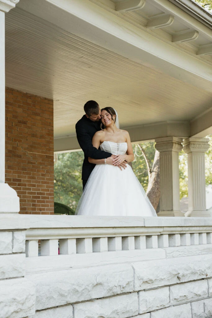 True bride Lauren posing with her husband in a hugging embrace