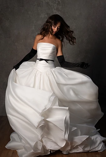 Bride wearing a-line drop waist wedding gown with bow belt detail