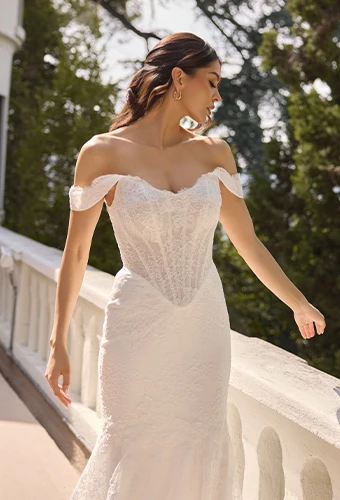 Bride wearing lace fit-and-flare wedding dress with off-the-shoulder dress