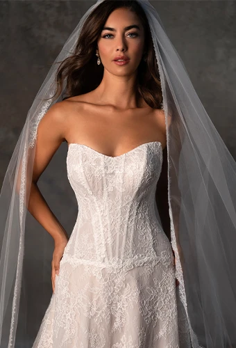 Bride wearing strapless lace wedding dress with sweetheart neckline and drop waist