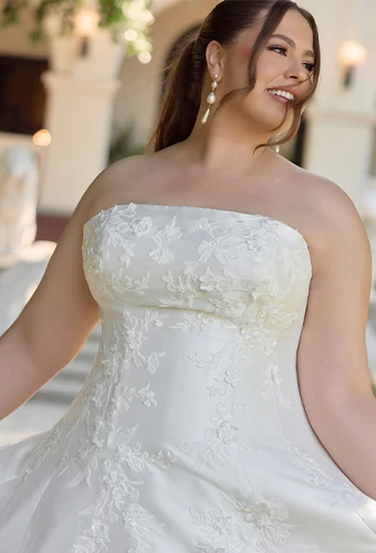 Plus size bride wearing strapless a-line wedding dress with lace appliques