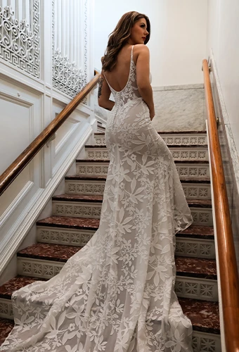 Bride wearing boho lace column wedding dress with thin spaghetti straps and scoop back