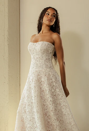 Bride wearing strapless boho lace wedding dress with drop waist