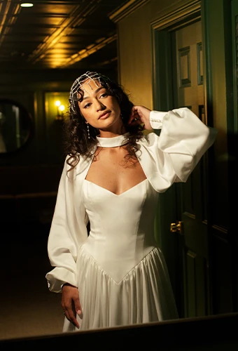 Bride wearing boho wedding dress with v-neckline and bell sleeves