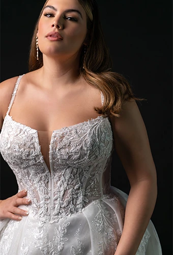 Plus size bride wearing sparkling lace wedding dress with notched v-neckline