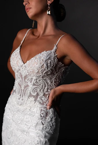 Bride wearing sparkling lace wedding dress with deep sweetheart neckline
