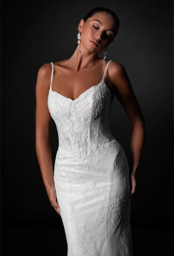 Bride wearing lace fit-and-flare wedding dress with sweetheart neckline and thin spaghetti straps