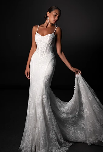 Bride wearing lace fit-and-flare wedding dress with sweetheart neckline and thin spaghetti straps