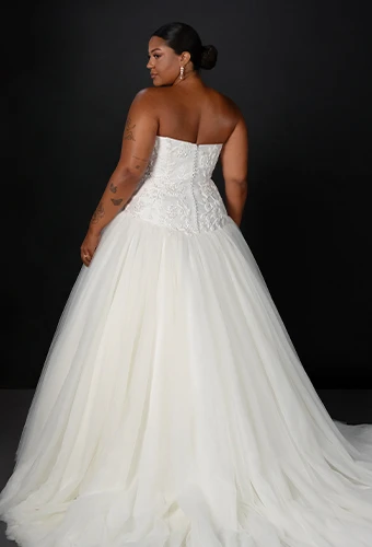 Plus size bride wearing strapless tulle ballgown with sparkling lace bodice
