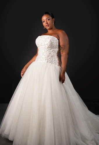 Plus size bride wearing strapless tulle ballgown with sparkling lace bodice