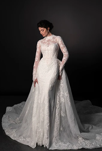 Bride wearing lace wedding dress with long sleeves and overskirt