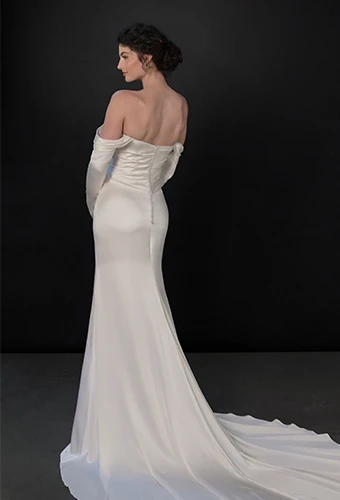 Bride wearing satin long sleeve wedding dress with scoop neckline
