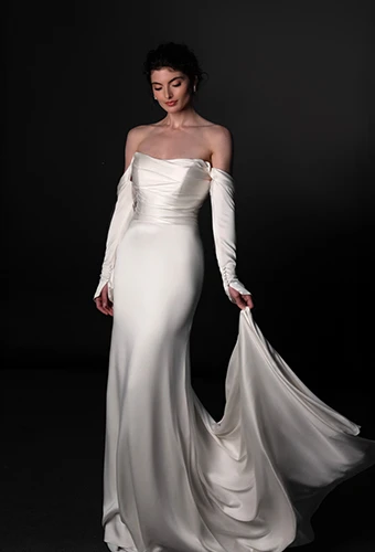 Bride wearing satin long sleeve wedding dress with scoop neckline