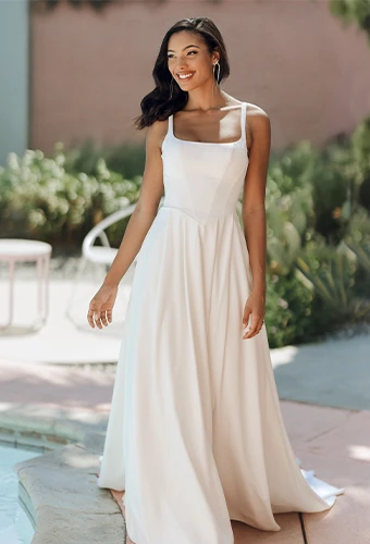 Bride wearing simple a-line wedding dress with scoop neckline and shoulder straps