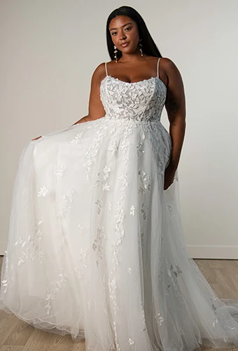 Plus size bride wearing a-line wedding dress with lace bodice and thin spaghetti straps