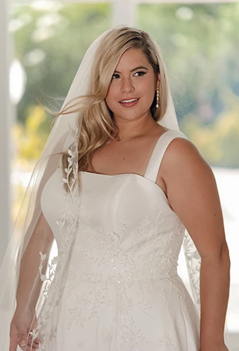 Plus size bride wearing a-line wedding dress with straight across neckline and shoulder straps