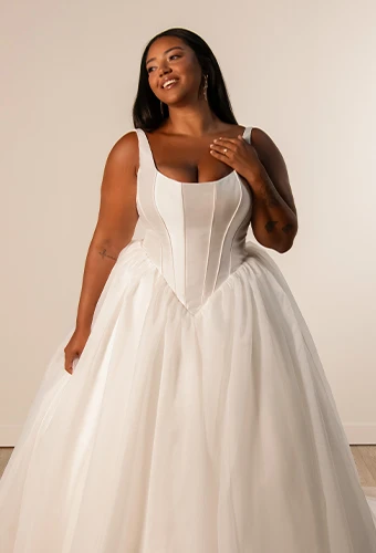 Plus size bride wearing tulle ballgown wedding dress with scoop neckline and shoulder straps