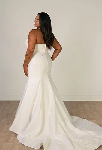 Plus size bride wearing mermaid wedding gown with straight across neckline and lace details