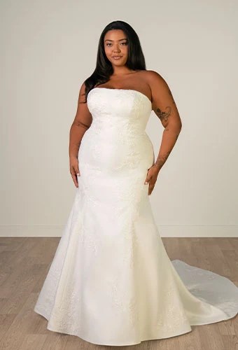 Plus size bride wearing mermaid wedding gown with straight across neckline and lace details
