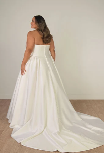 Plus size bride wearing simple strapless wedding dress with straight across neckline