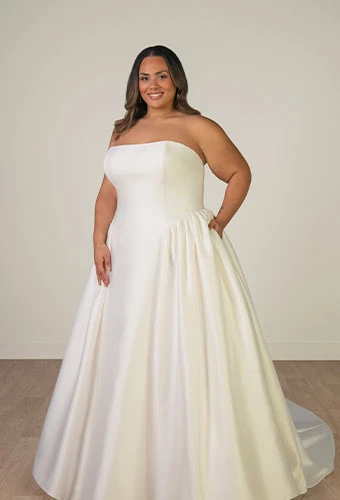 Plus size bride wearing simple strapless wedding dress with straight across neckline